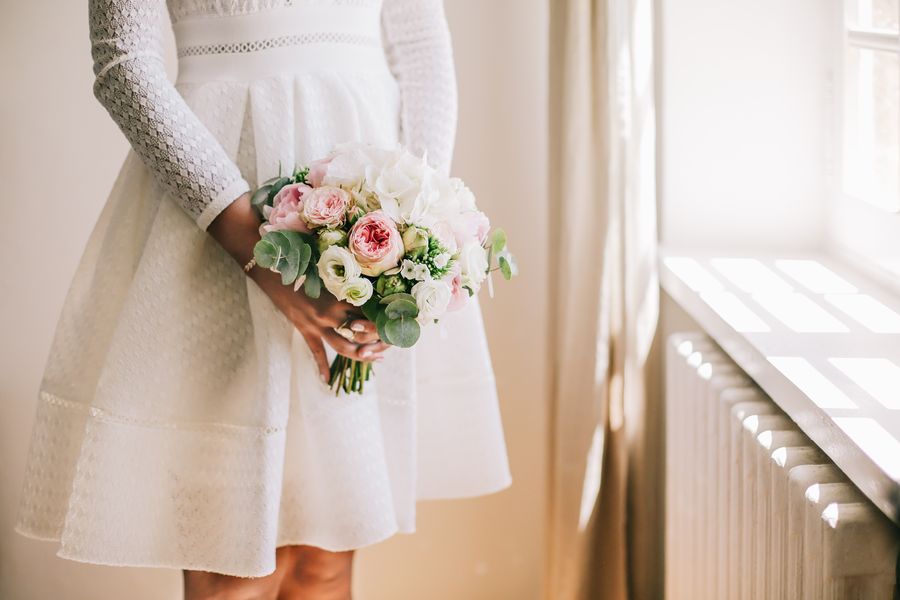 La mariée en robe civile avec son bouquet de fleurs