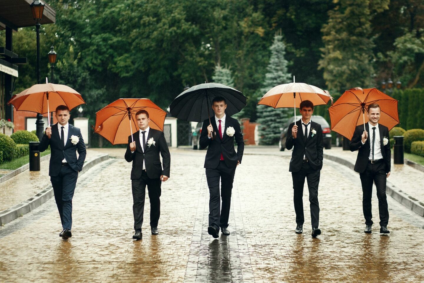 Photos de groupe de mariage avec des parapluies. Le marié et ses garçons d'honneur et témoins pour une photo de groupe originale