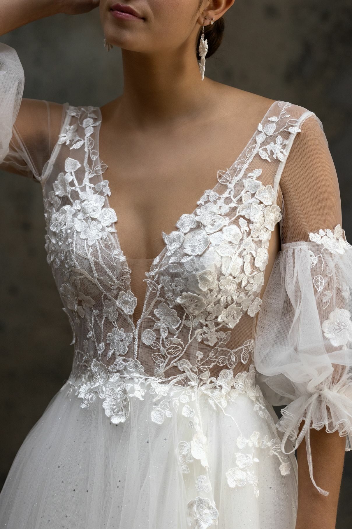 Robe de mariée princesse 2025 avec décolleté à bretelles effet illusion qui est parsemé d’incrustations de tulle brodé aux motifs fleuris.