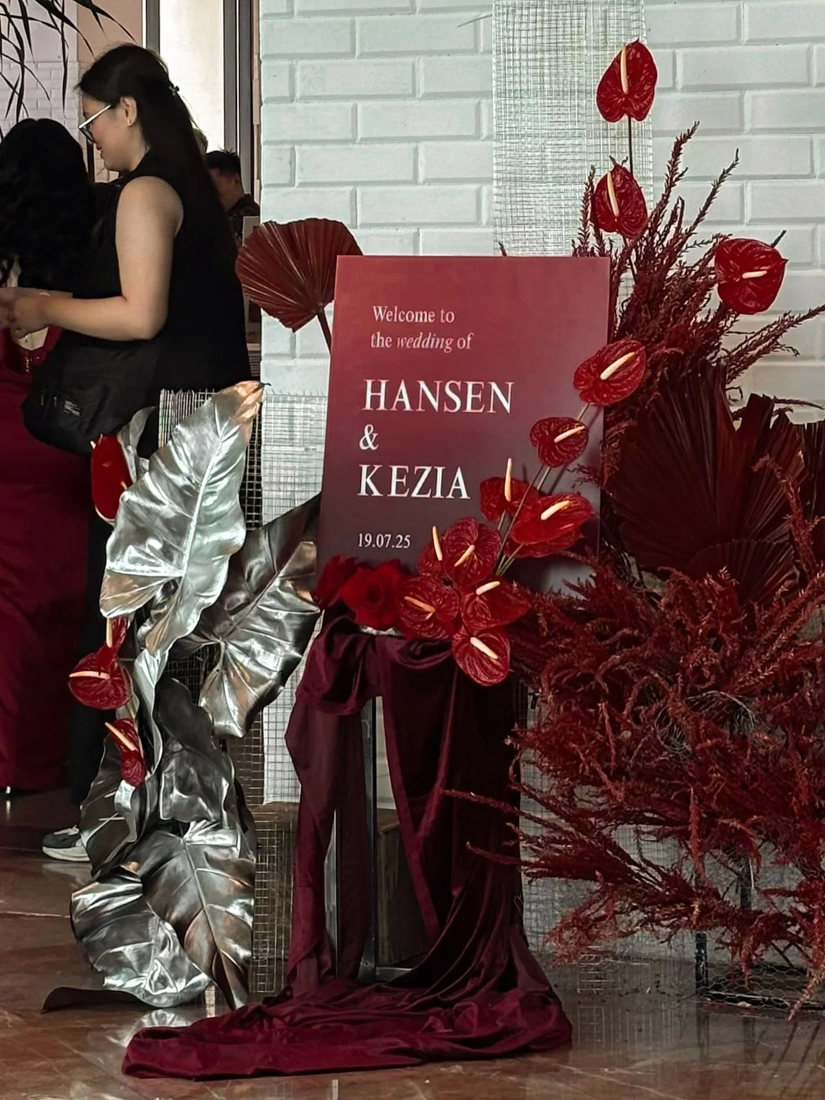 panneau de bienvenu de mariage avec anthuriums bordeaux et feuilles argent